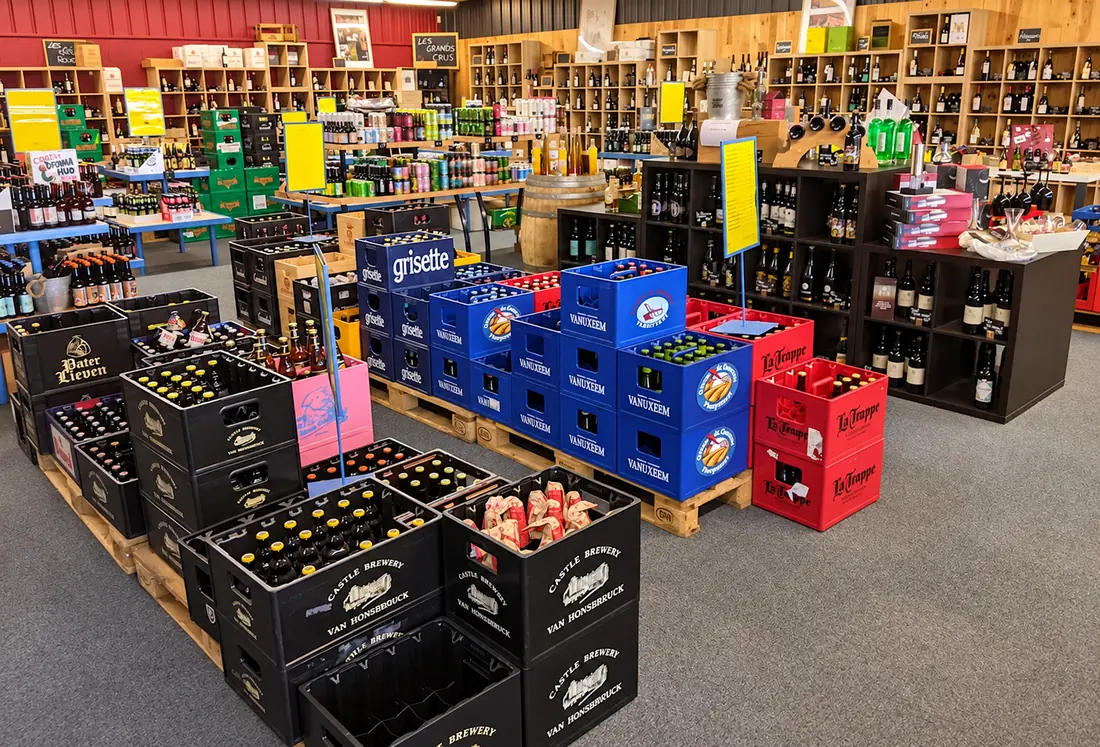 La cave de Chez TonTon : casiers de bières et rayonnages de bouteilles.